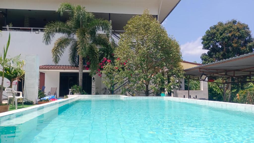 a large swimming pool in a house with trees at 449 Airport Phuket in Nai Yang Beach