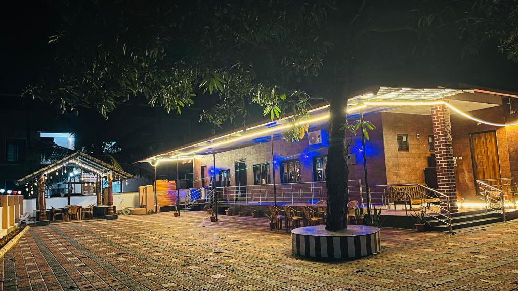 a building with a tree in front of it at night at Odrine's abode - Udupi in Kalyānpur
