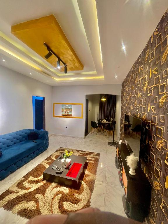 a living room with a blue couch and a fireplace at Ebest homes in Benin City