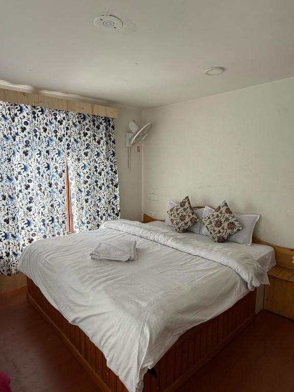 a large bed in a bedroom with a window at Mughal resort pahalgam in Pahalgām