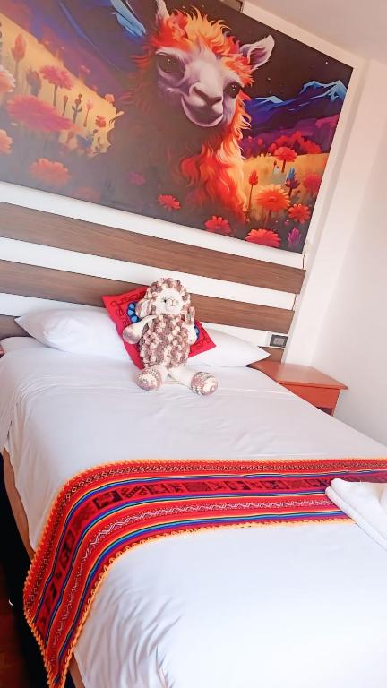 a stuffed animal sitting on top of a bed at Mirador All Sur Cusco in Cusco