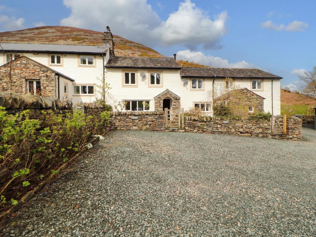 a large white house with a stone fence at Two Town End in Penrith