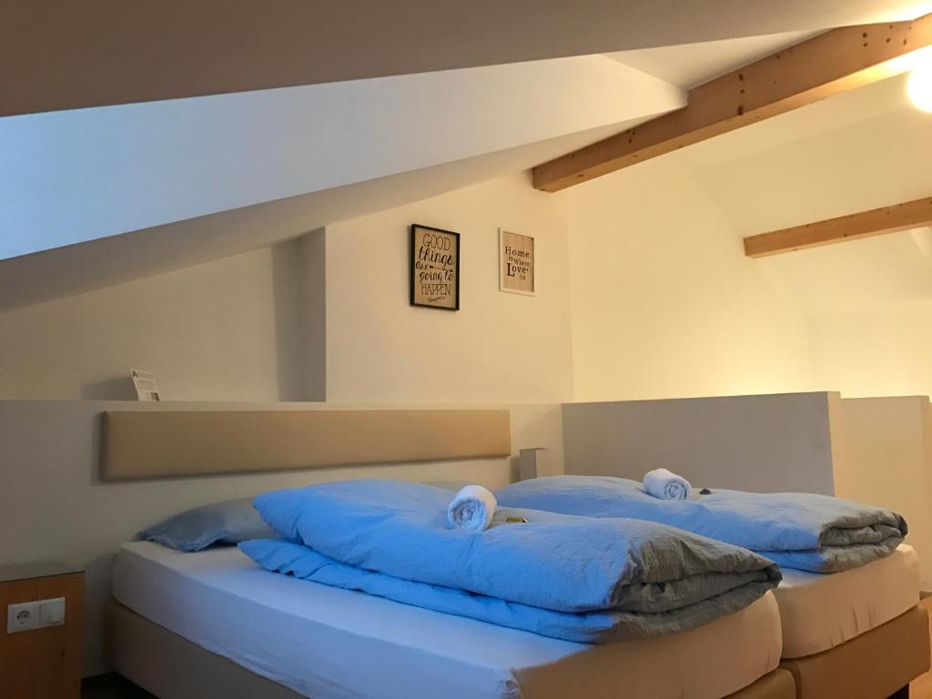 2 niebieskie poduszki na łóżku w pokoju w obiekcie Argentieri Guesthouse w mieście Bolzano