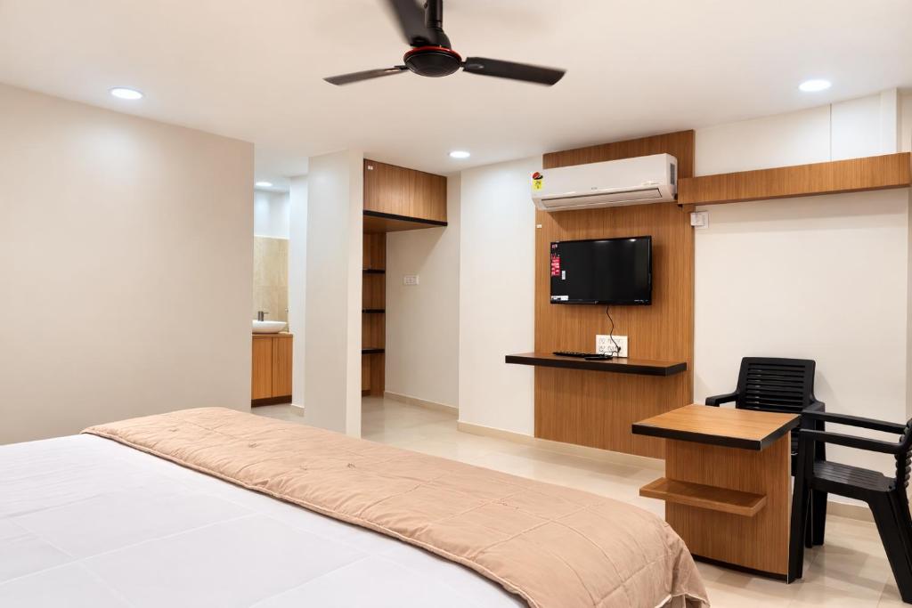 a bedroom with a bed and a flat screen tv at Vihari Foodway INN in Gooty