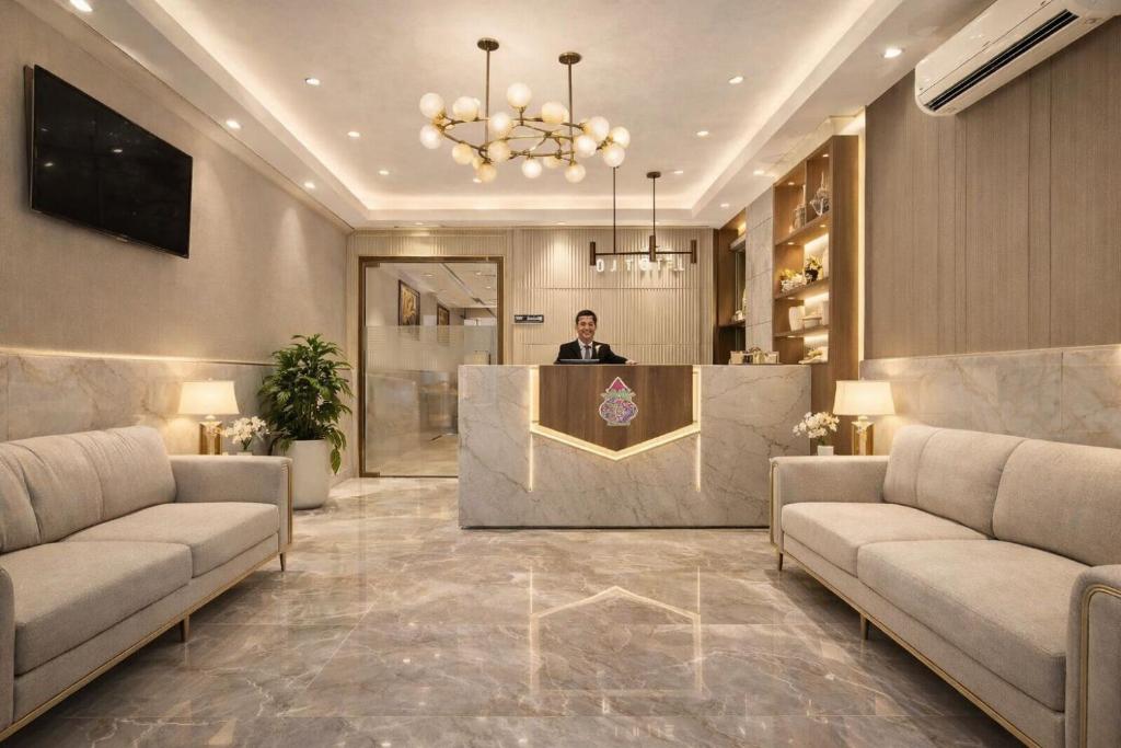 a man standing at a reception desk in a lobby at Velocity Corporate Hotel TERMINAL 2,3 Delhi Airport With- Free Airport Pickup in New Delhi