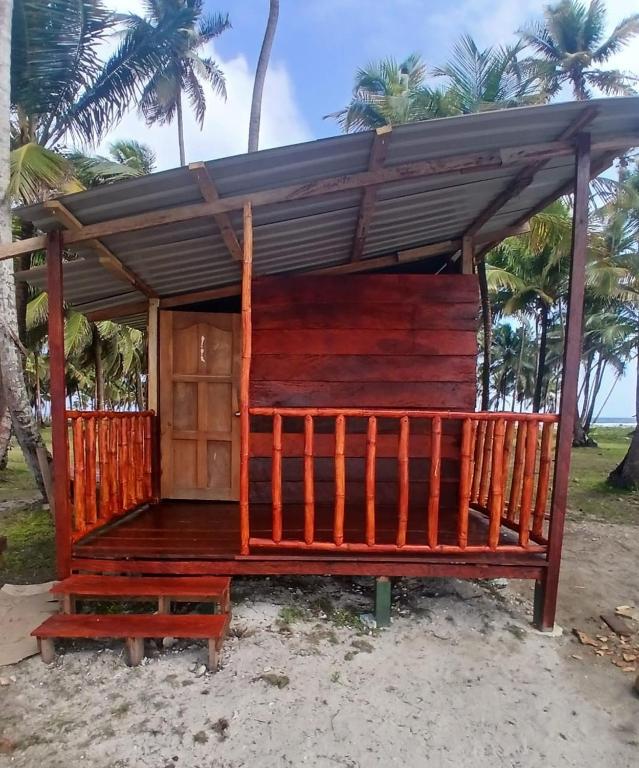 a wooden house on the beach with palm trees at San Blas island cabins in Waisalatupo