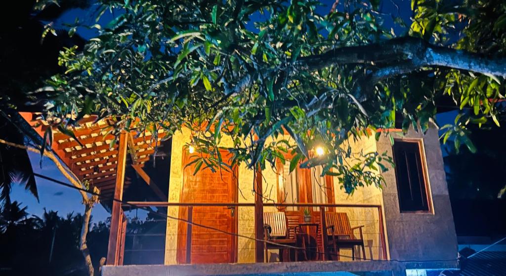 a house with a tree in front of it at SRI Villa in Busse
