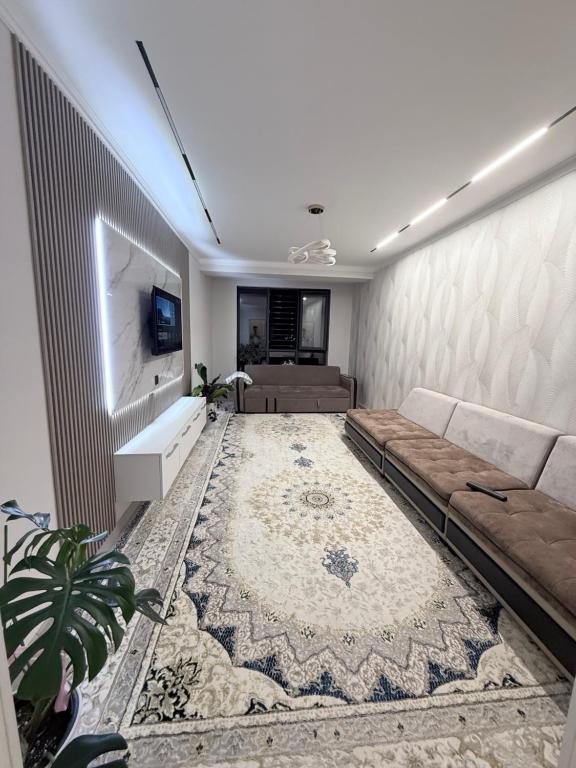 a living room with a couch and a tv at Frunze Residence in Osh