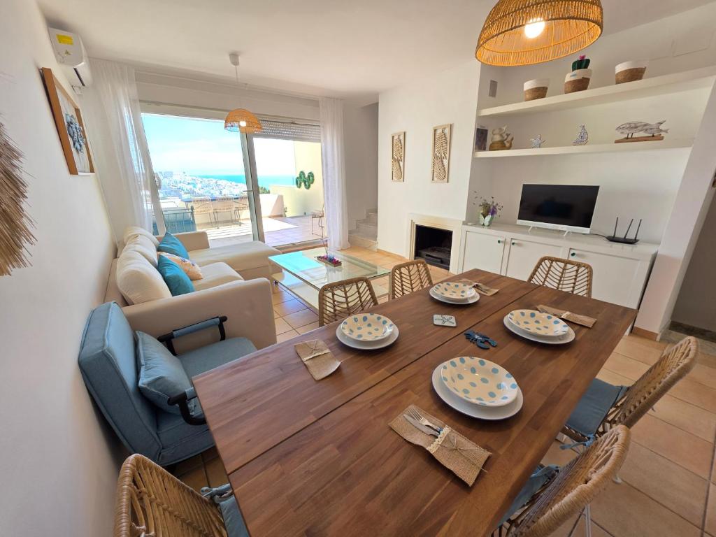 a dining room and living room with a table and chairs at ALBA MARINA Experience Peñiscola in Peniscola