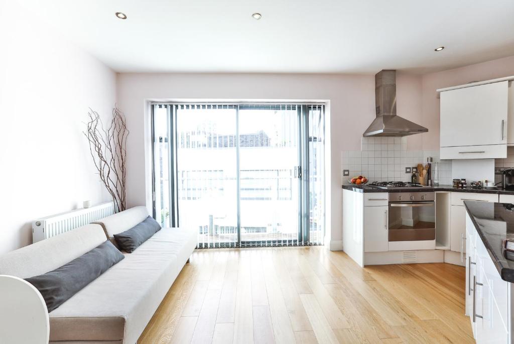 a white living room with a couch and a kitchen at Fabulous Apartment Central London in London