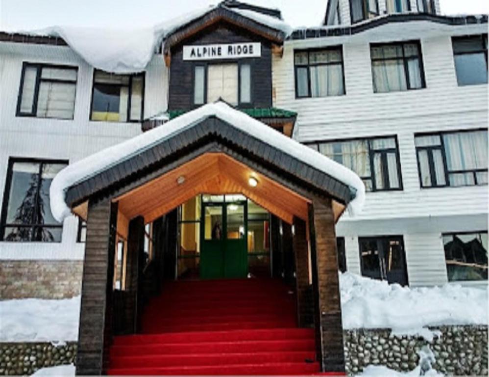 a building with a red staircase in the snow at Hotel Alpine Ridge, Gulmarg in Gulmarg