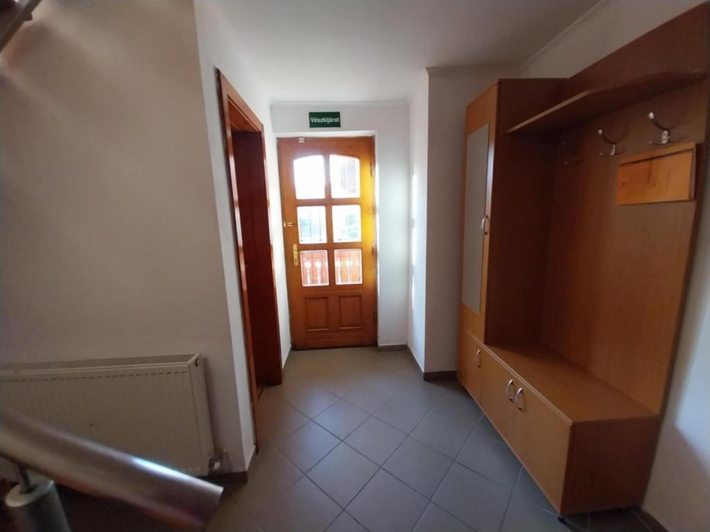 a hallway with a wooden door and a staircase at Mohos Vendégfogadó in Kelemér