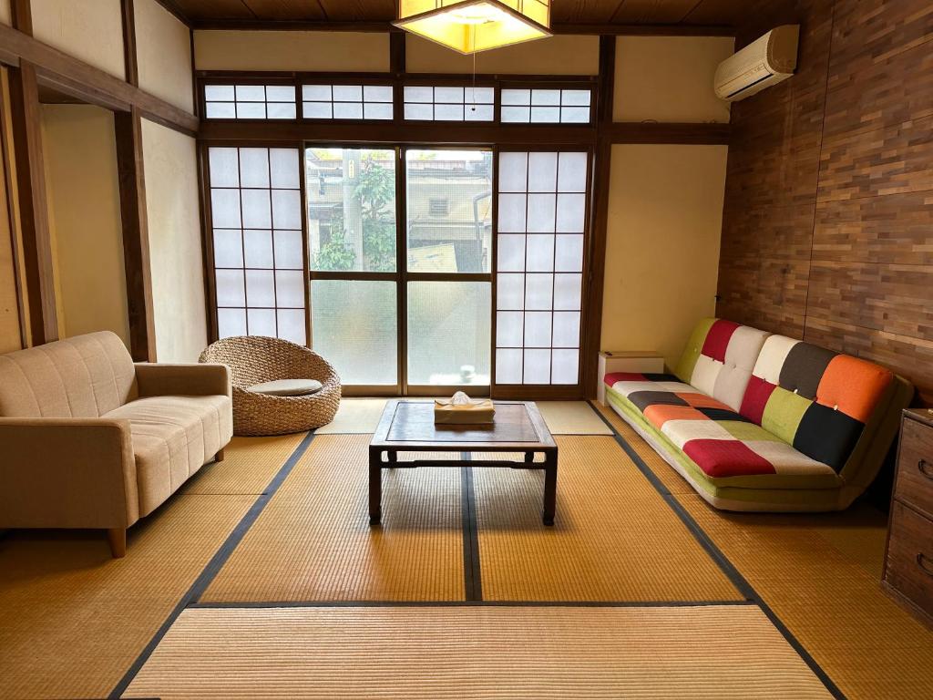 a living room with a couch and a coffee table at Guesthouse Azumaya 2nd in Matsumoto