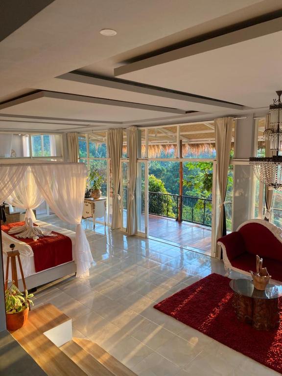 a bedroom with a red bed and a large window at Oceanview Cottage Cempaga - entire 2 BR Bungalow 135 sqm in Temukus