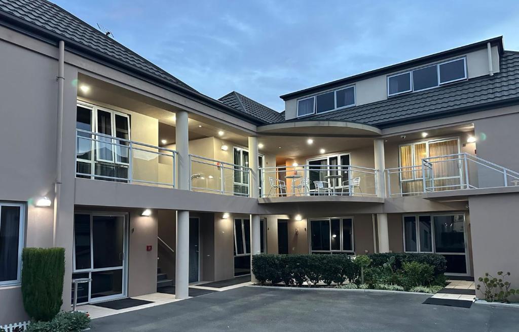 a large house with a balcony and a driveway at ASURE Centrepoint Motel in Christchurch