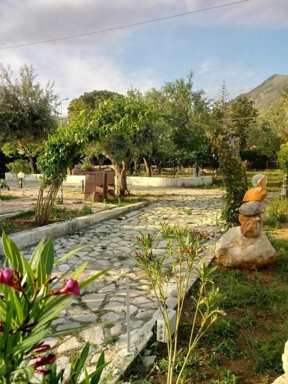a stone path in a garden with a stone statue at La Costa del Pavone in Carini