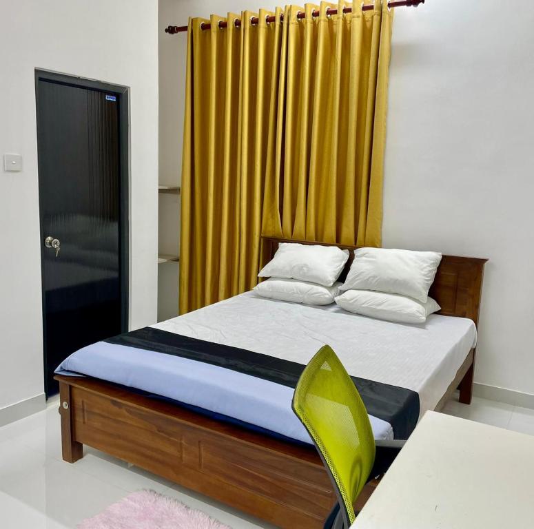 a bedroom with a bed with a yellow curtain at Elegant Mist Villa in Nuwara Eliya