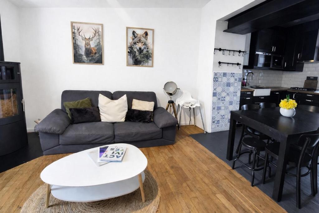 a living room with a couch and a table at Maison cosy 4-6 pers avec terrasse Lac & hyper centre à pied 300 m Linge inclus in Gérardmer