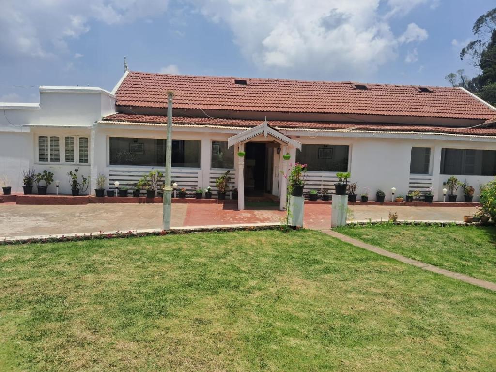 a white house with a red roof at Milestone Heritage Inn in Jāmb