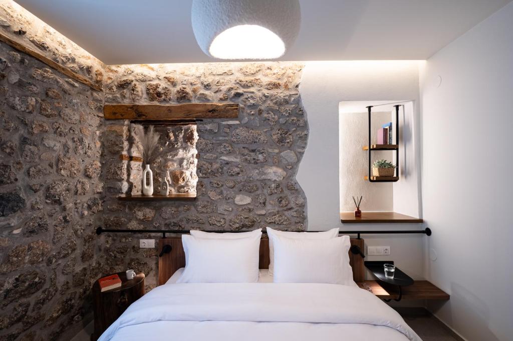 a bedroom with two beds and a stone wall at The Alley in Litochoro