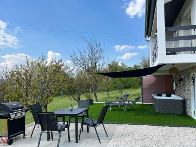a patio with a table and chairs and a grill at Horizon Hill in Cserszegtomaj
