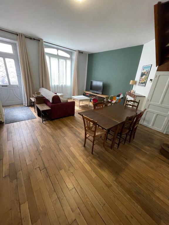 a living room with a table and a couch at Le gîte de Marie in Gramat
