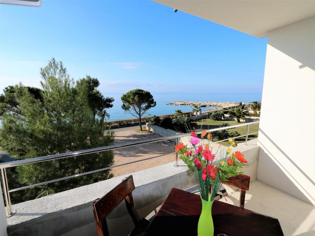 a vase of flowers on a table on a balcony at Antodo in Novalja