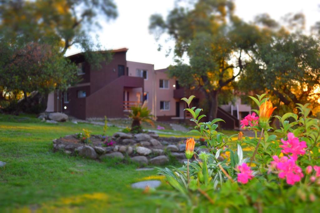 un jardín frente a una casa con flores en Tatainti Chalet & Suite en Merlo