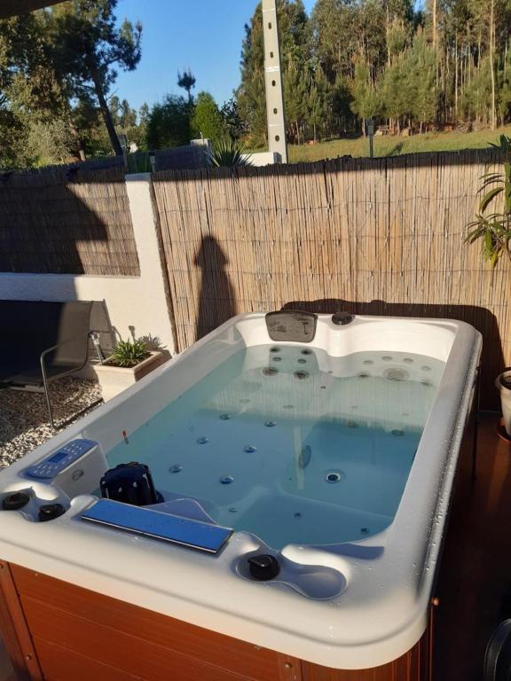 a bath tub sitting on top of a patio at Luxury Romantic Retreat with Hot Tub & Pool in Tábua