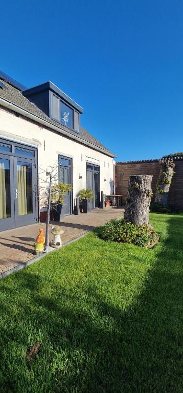 a house with a yard with a fire hydrant in the grass at DuinDroom bovenappartement, Beverwijk in Beverwijk