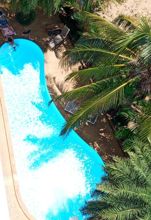an overhead view of a blue swimming pool with palm trees at Cozy apartment with a sea view in Ban Bo Sai Klang