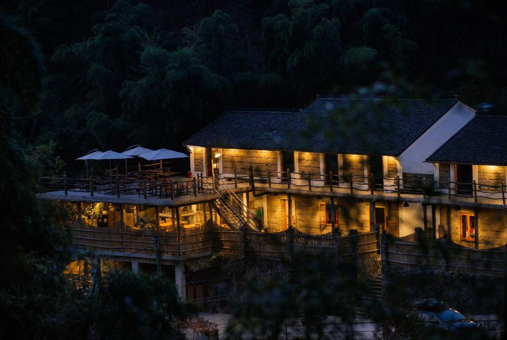 un bâtiment éclairé la nuit avec des lumières dans l'établissement Moganshan Solvang Village Boutique Hotel, à Deqing