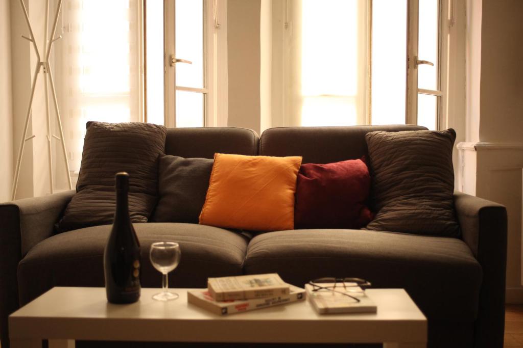 a couch with colorful pillows on it with a table at Lyon Standing Historic City Apartment in Lyon