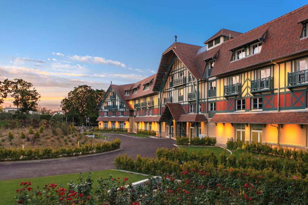 a row of buildings with a courtyard with flowers at Renaissance Paris Hippodrome de St. Cloud Hotel in Rueil-Malmaison