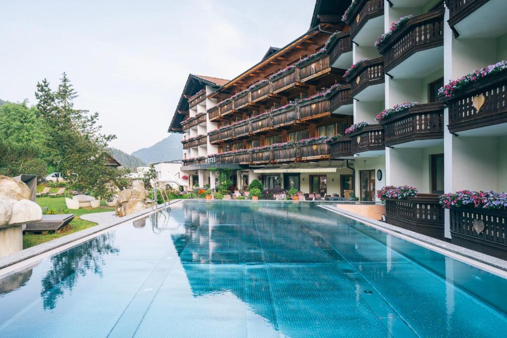 a swimming pool at a hotel with a resort at Der Kirchheimerhof - Superior in Bad Kleinkirchheim