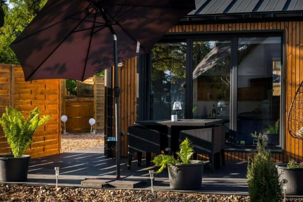 a patio with a table and an umbrella at Lutek in Olsztynek