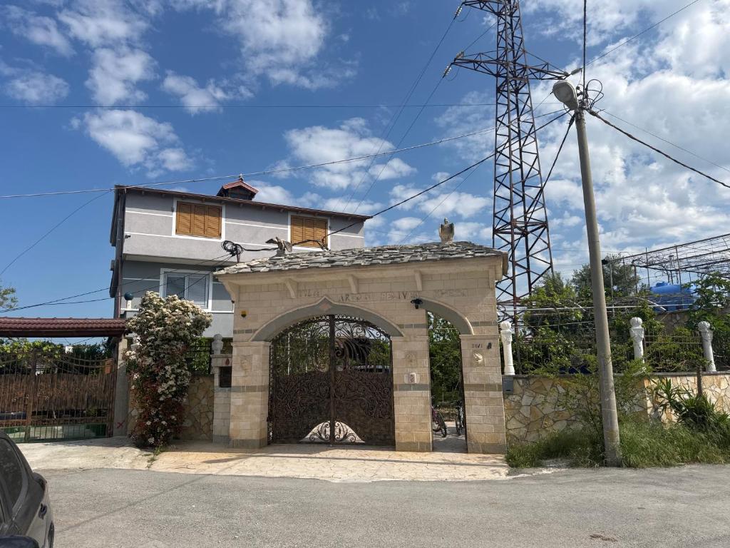 a building with a gate in front of a house at Villa 24 maj cole vlore in Vlorë