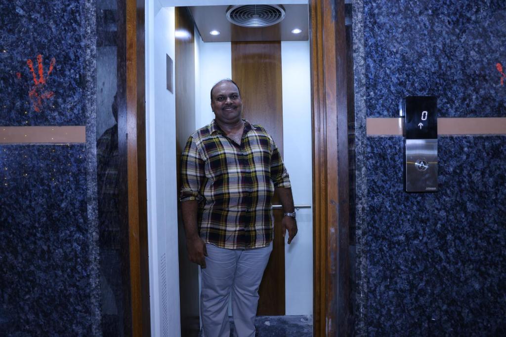 a man standing in front of a elevator at PNR CONVENTION hall in Jāmb