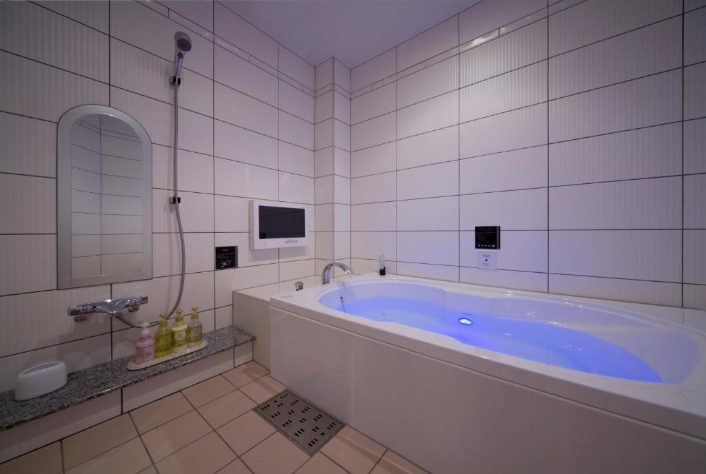La salle de bains est pourvue d'une grande baignoire et d'une télévision. dans l'établissement JEWEL HOTEL LUXURY MODERN (Adult Only), à Miyoshi