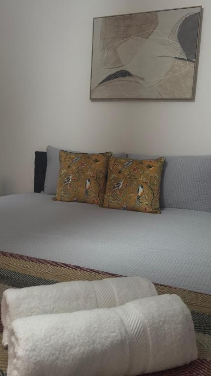 a bed with two pillows and a white blanket at King Room sheared house in Bristol