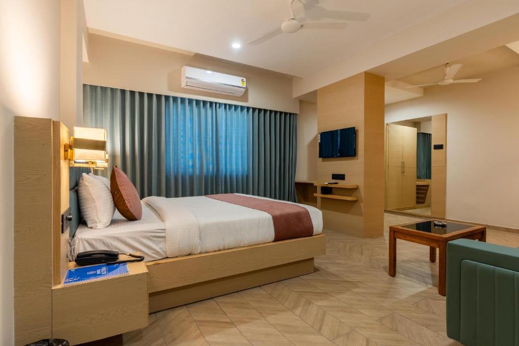 a hotel room with a bed and a bathroom at Hotel Altura CHHATRAL in Nandāsan