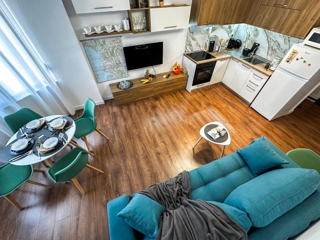 a living room with a blue couch and a kitchen at 214 The Coastal Nest in Durrës