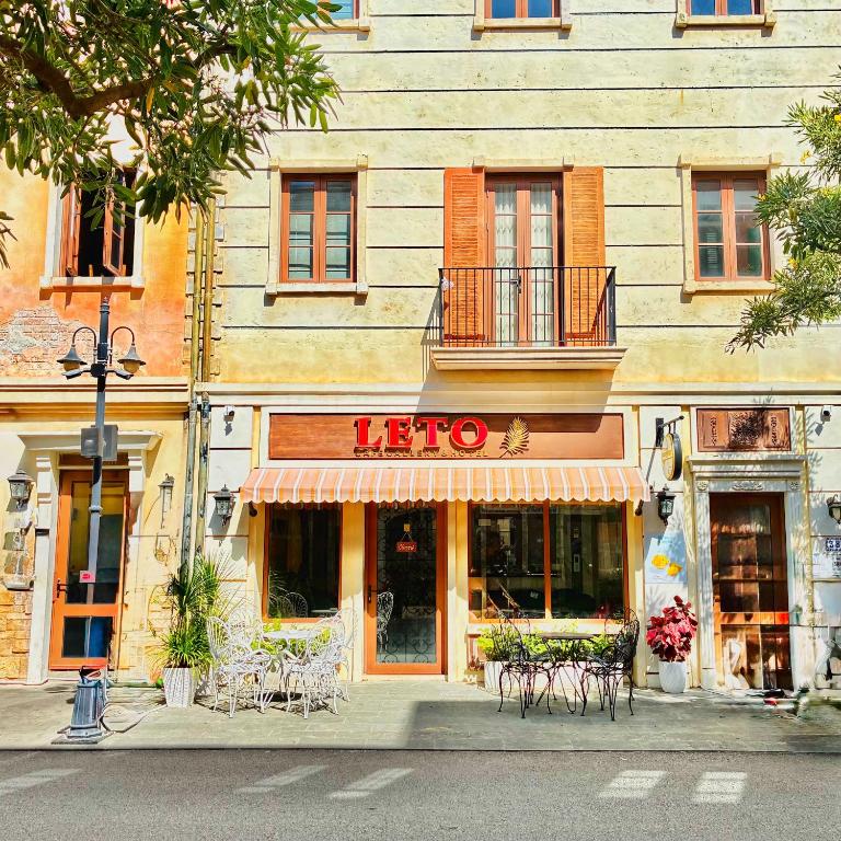 a store with tables and chairs in front of a building at Leto Hotel Central Sunset Town in Phú Quốc