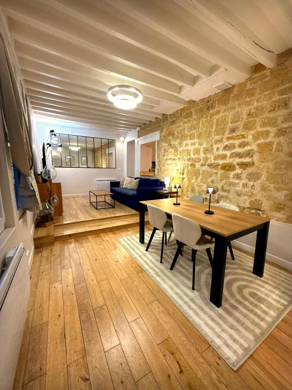 a living room with a table and chairs and a couch at DUPLEX SUBLIME ET LUMINEUX au CENTRE VILLE 10 minutes de Paris Parking privée souterrain in Rueil-Malmaison