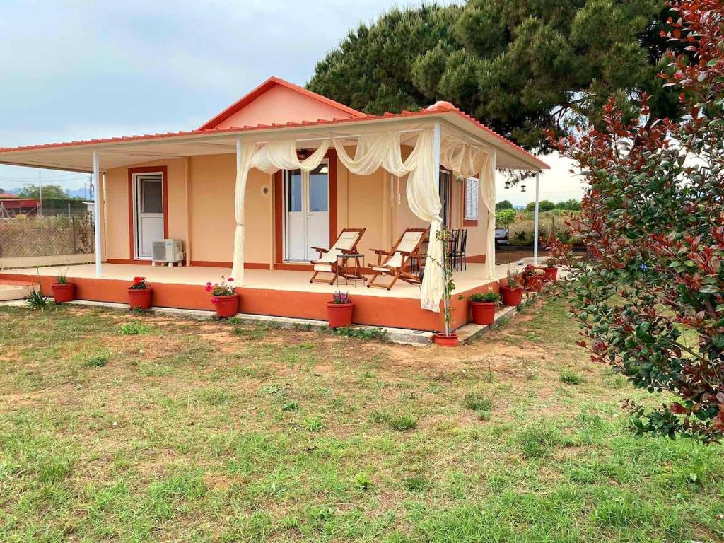 a small house with two chairs in a yard at CouCouNaries in Nisís Ánidhro