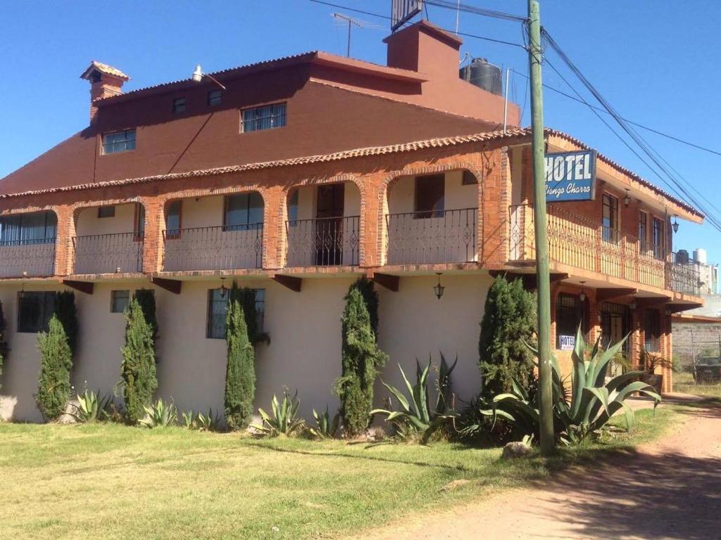 een oud gebouw met een bord ervoor bij Hotel Lienzo Charro 1 in Huasca de Ocampo