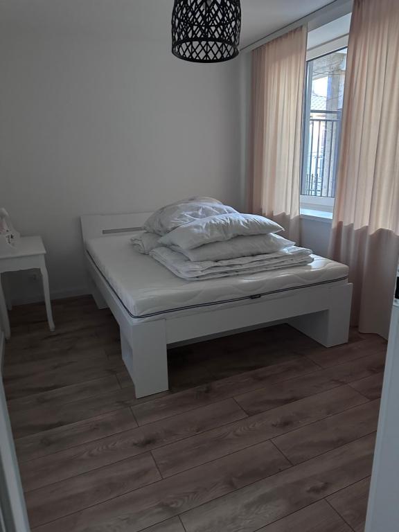 a white bed in a room with a window at Apartament Ełcka 2- Mazury in Orzysz