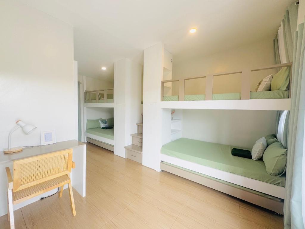 a bedroom with two bunk beds and a desk at Casa Augusto in Santo Tomas