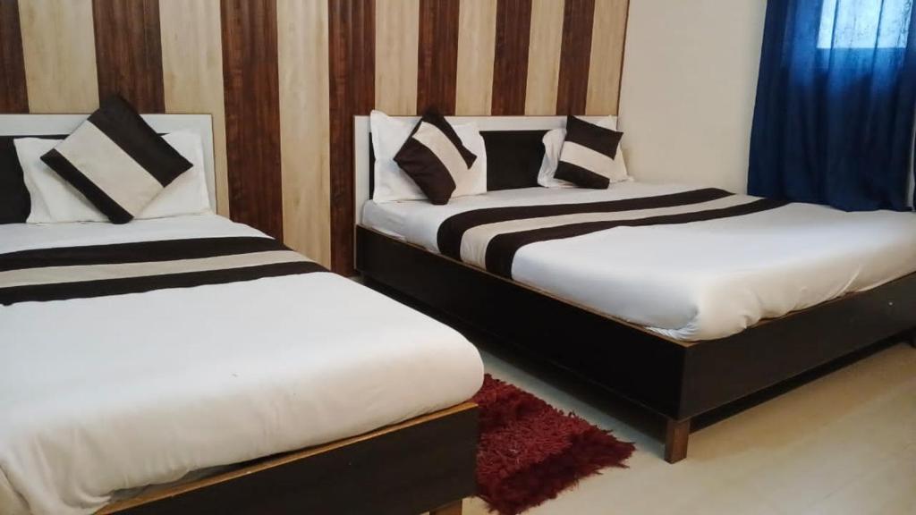 two beds sitting next to each other in a room at Nepal VaNaVaS Retreat in Changunarayan