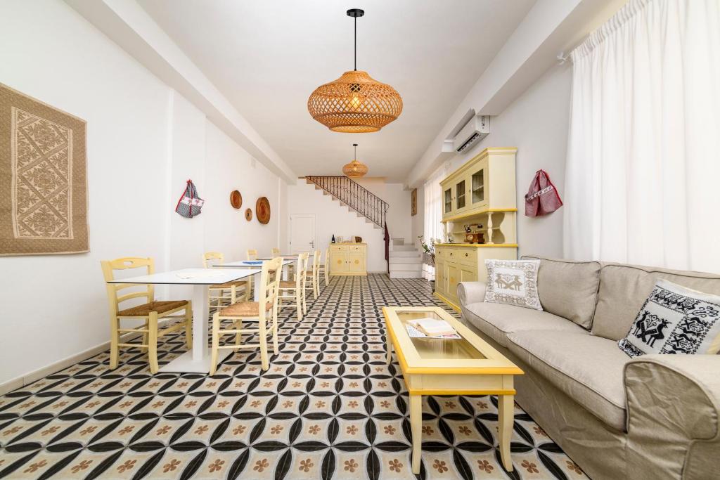 a living room with a couch and a table at NG Guest House Ammentos in Olbia